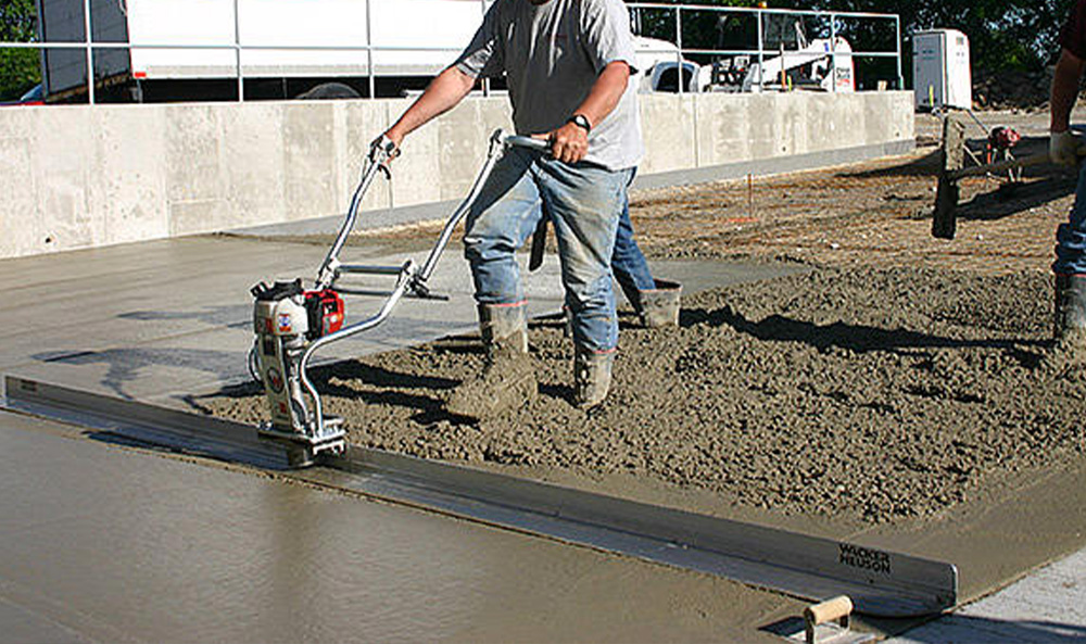 Niveler le béton avec une règle vibrante